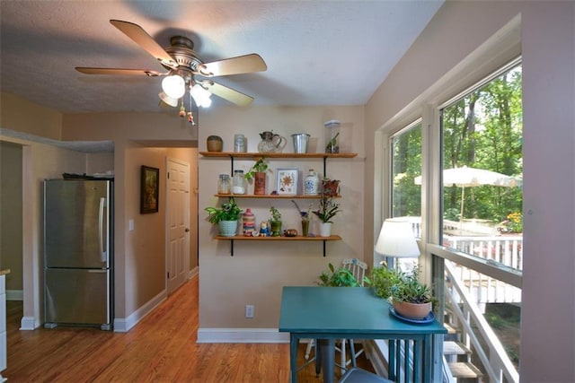 interior space featuring a textured ceiling, stainless steel fridge, and light wood-type flooring