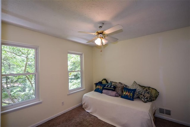 bedroom featuring ceiling fan and dark carpet