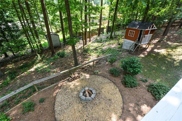 view of yard featuring a storage unit and a fire pit