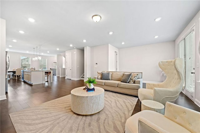 living area with recessed lighting, dark wood-style flooring, baseboards, and stairs