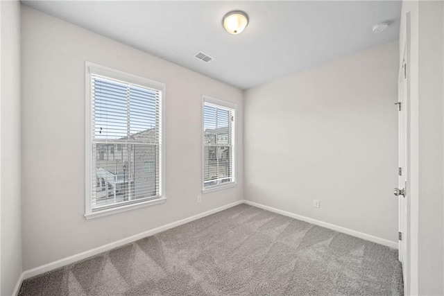 carpeted empty room with visible vents and baseboards