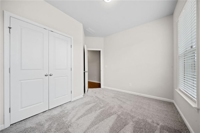 unfurnished bedroom featuring a closet, carpet, and baseboards