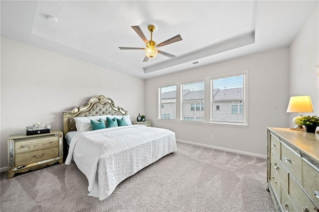 bedroom with visible vents, baseboards, a raised ceiling, a ceiling fan, and carpet