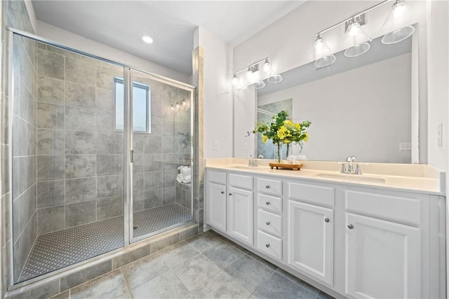 bathroom featuring double vanity, a shower stall, and a sink