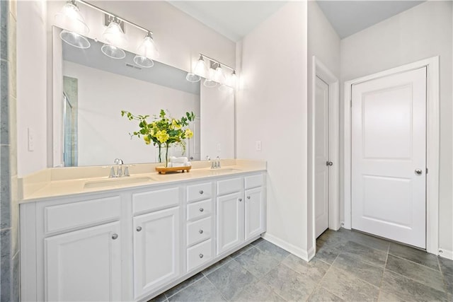 full bath with double vanity, a shower with door, baseboards, and a sink