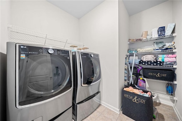 laundry area featuring laundry area, baseboards, and washing machine and clothes dryer