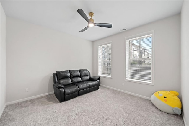 living area featuring visible vents, carpet floors, a ceiling fan, and baseboards