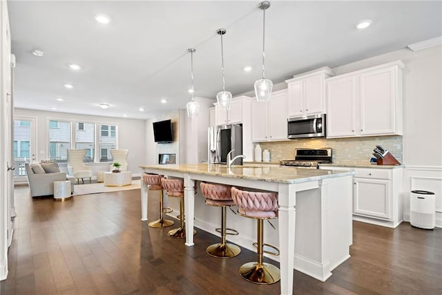 kitchen featuring stainless steel appliances, dark wood-type flooring, backsplash, and white cabinets