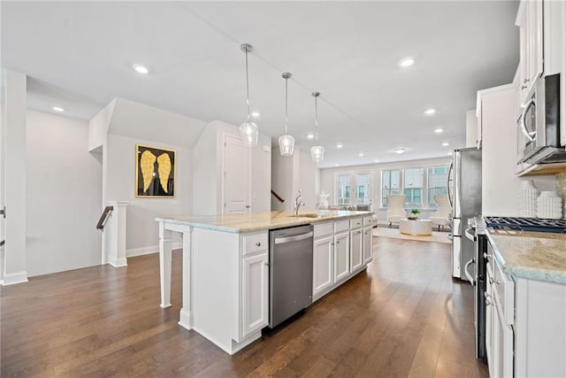 kitchen with stainless steel appliances, a breakfast bar, white cabinetry, dark wood-style floors, and an island with sink