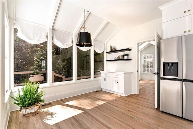 unfurnished sunroom featuring visible vents and vaulted ceiling