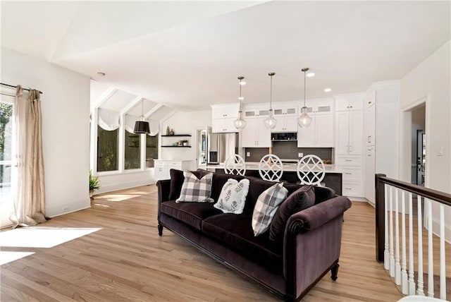 living room with recessed lighting, light wood-style flooring, baseboards, and lofted ceiling