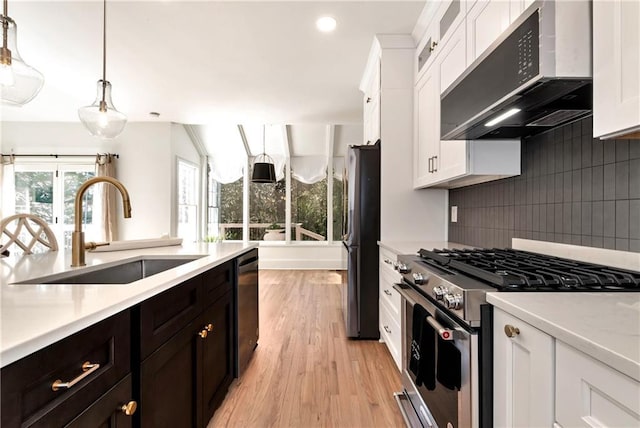 kitchen featuring range hood, a sink, black appliances, light countertops, and white cabinetry