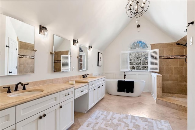 bathroom with double vanity, walk in shower, and a sink