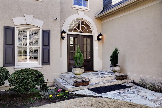 doorway to property featuring stucco siding