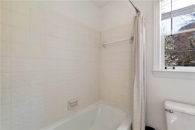 bathroom featuring shower / tub combo and toilet