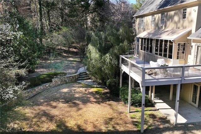 view of yard with a patio area, a wooden deck, and a sunroom