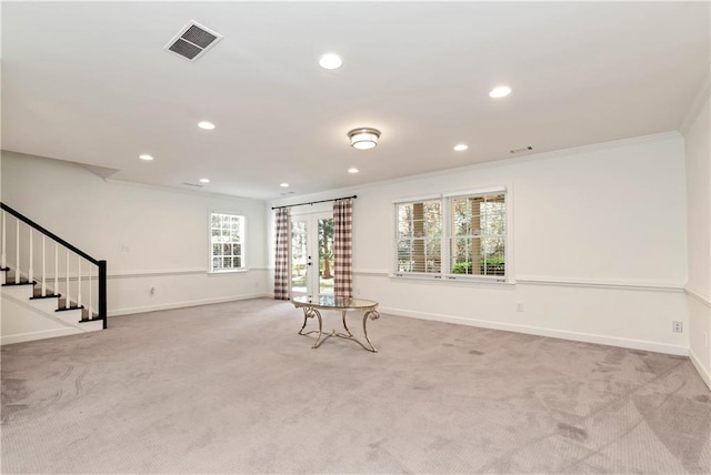 unfurnished room with visible vents, light carpet, baseboards, and stairway