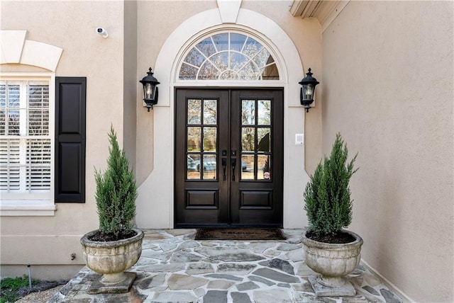 property entrance with french doors and stucco siding