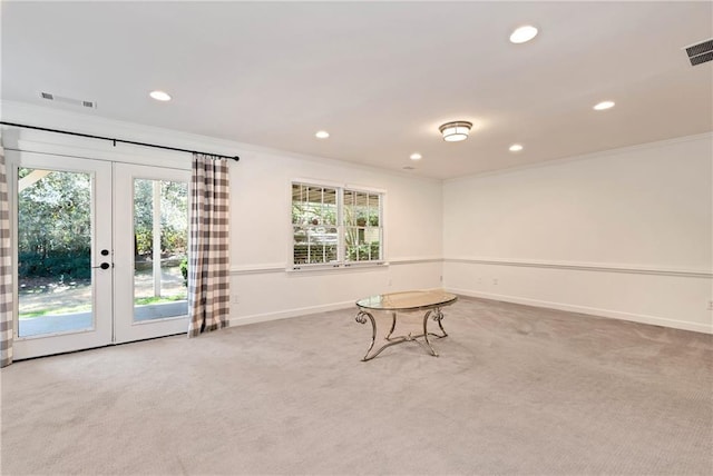 unfurnished room featuring french doors, carpet flooring, and crown molding