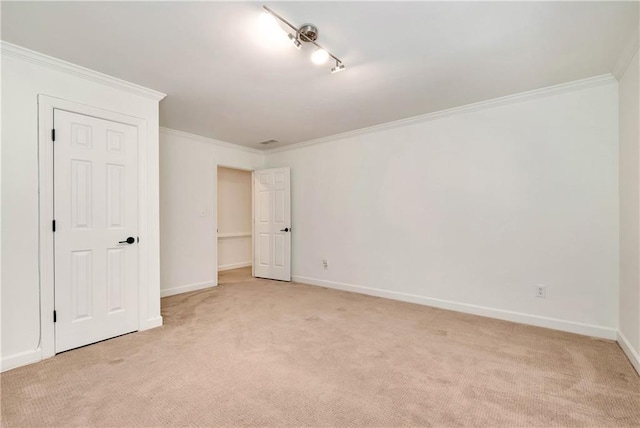 unfurnished bedroom featuring crown molding, baseboards, and light carpet