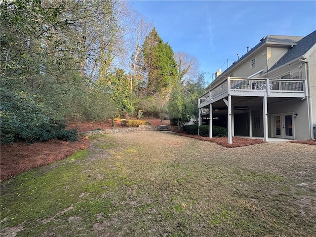 view of yard featuring french doors and a wooden deck