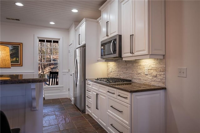 kitchen featuring stone tile floors, visible vents, white cabinetry, appliances with stainless steel finishes, and backsplash