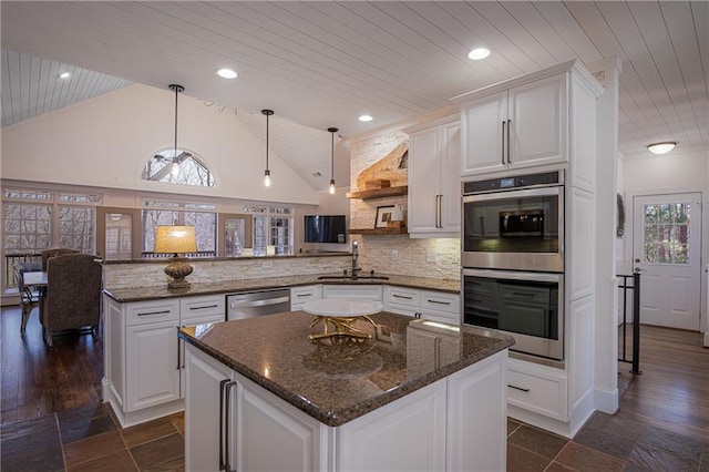 kitchen featuring stainless steel appliances, a peninsula, a sink, wood ceiling, and tasteful backsplash