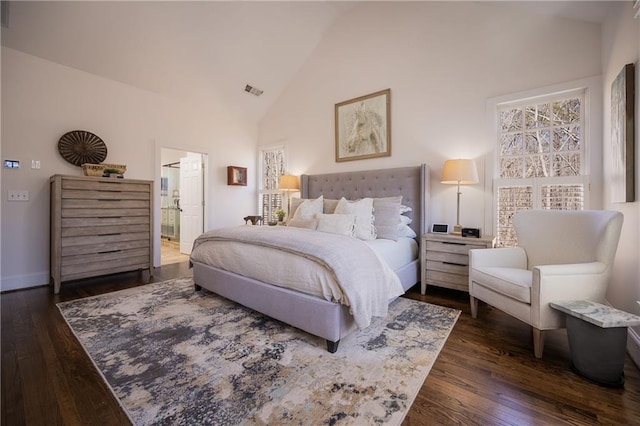 bedroom featuring dark wood-style floors, connected bathroom, high vaulted ceiling, and baseboards