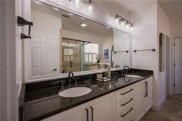 bathroom with visible vents, a sink, a shower stall, and double vanity