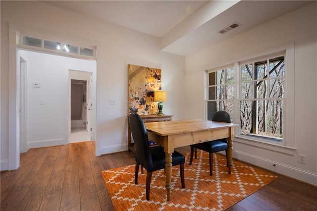 dining space with baseboards, visible vents, and hardwood / wood-style floors