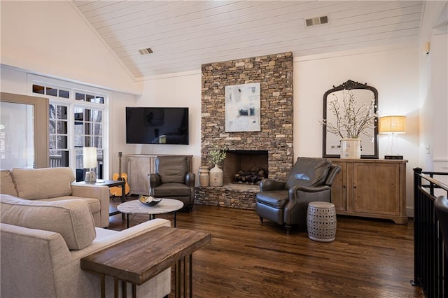 living area featuring dark wood-style floors, visible vents, and a stone fireplace