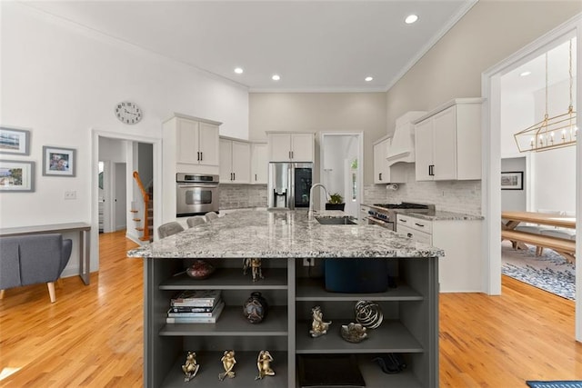 kitchen featuring tasteful backsplash, a large island with sink, light stone counters, and stainless steel appliances