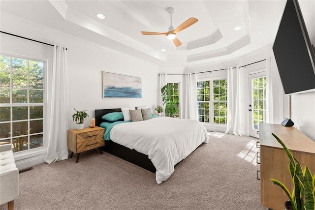 carpeted bedroom featuring a raised ceiling, ceiling fan, and crown molding