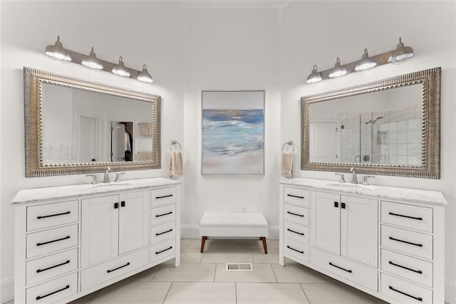 bathroom with tile patterned flooring, vanity, and walk in shower