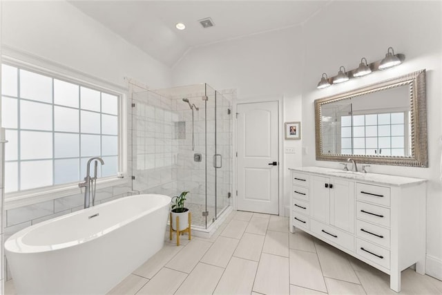 bathroom featuring tile patterned flooring, plenty of natural light, vanity, and vaulted ceiling