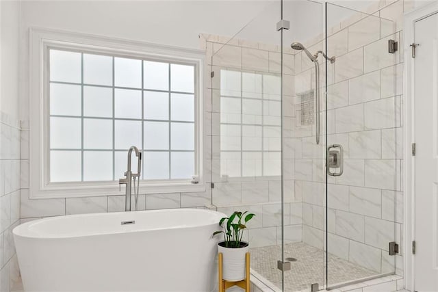 bathroom with plenty of natural light, tile walls, and shower with separate bathtub