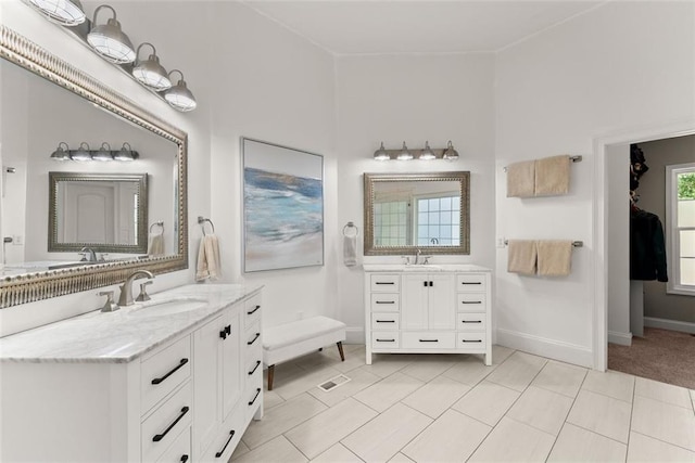 bathroom featuring tile patterned flooring, vanity, and a healthy amount of sunlight