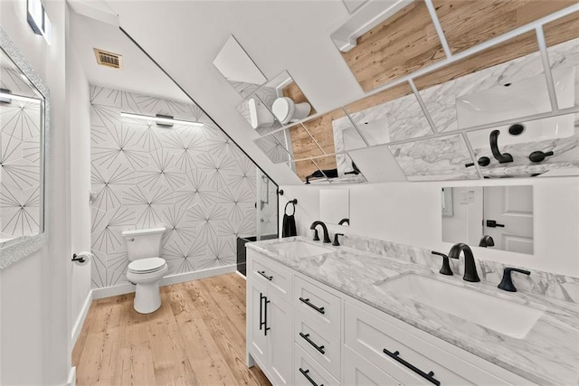 bathroom with a shower, wood-type flooring, vanity, and toilet