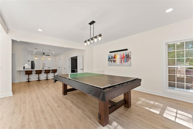 game room with light hardwood / wood-style floors and sink