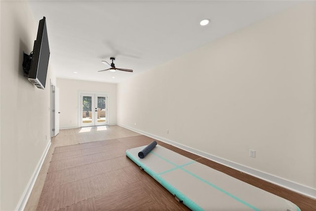 exercise area featuring ceiling fan, french doors, and light hardwood / wood-style flooring