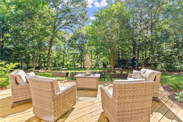 wooden terrace featuring outdoor lounge area and a trampoline