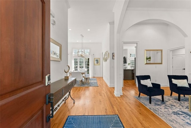 foyer featuring a chandelier, light hardwood / wood-style floors, and ornamental molding