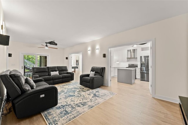 living room featuring ceiling fan and light hardwood / wood-style floors