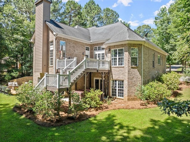 rear view of house with a wooden deck and a yard