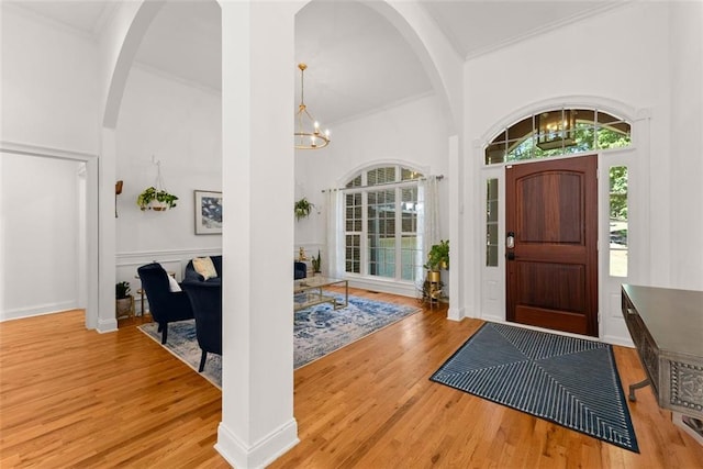 foyer featuring light hardwood / wood-style floors, a high ceiling, and an inviting chandelier