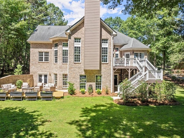 back of property with a lawn, a wooden deck, and an outdoor living space