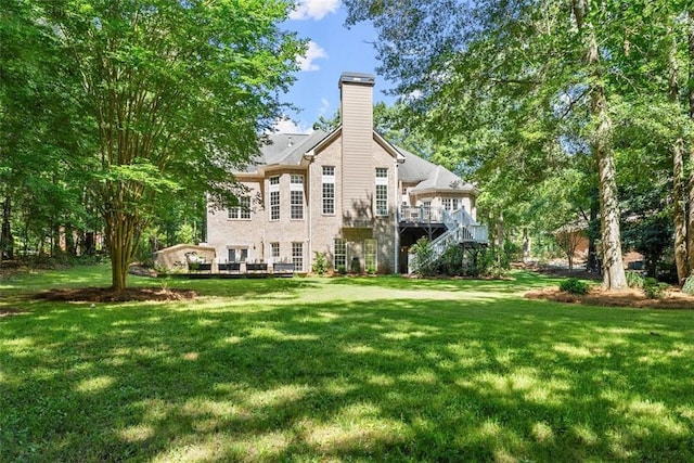 rear view of property with a yard and a wooden deck