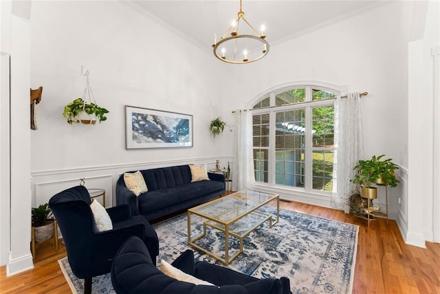 living room with crown molding, a chandelier, and hardwood / wood-style flooring