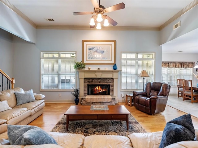 11 Stillwater Way, Hoschton, GA 30548 - living area featuring ceiling fan, plenty of natural light, ornamental molding, a stone fireplace, and wood finished floors