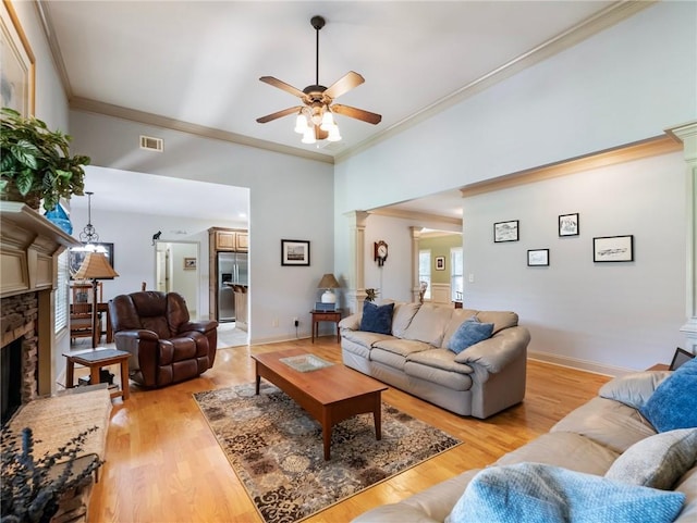 11 Stillwater Way, Hoschton, GA 30548 - living area featuring crown molding, ceiling fan, ornate columns, a stone fireplace, and light wood-style flooring